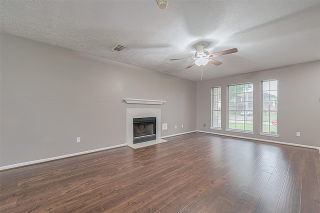 10834 Glenora Dr, Houston, TX 77065 - unfurnished living room with ceiling fan, dark wood-type flooring, a textured ceiling, and a tiled fireplace