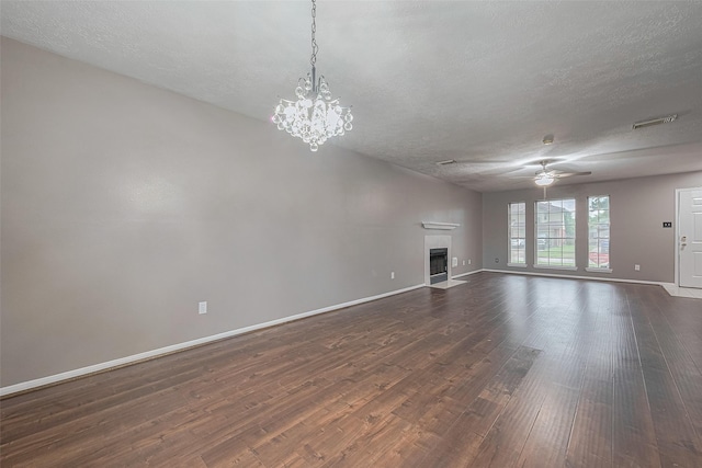 10834 Glenora Dr, Houston, TX 77065 - unfurnished living room featuring dark wood-style flooring, ceiling fan, a fireplace with flush hearth, a textured ceiling, and a chandelier
