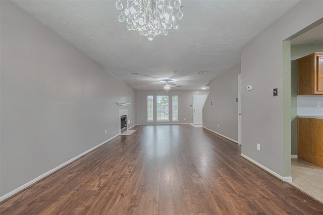 10834 Glenora Dr, Houston, TX 77065 - unfurnished living room with a textured ceiling, a fireplace with flush hearth, ceiling fan, dark wood-type flooring, and a chandelier
