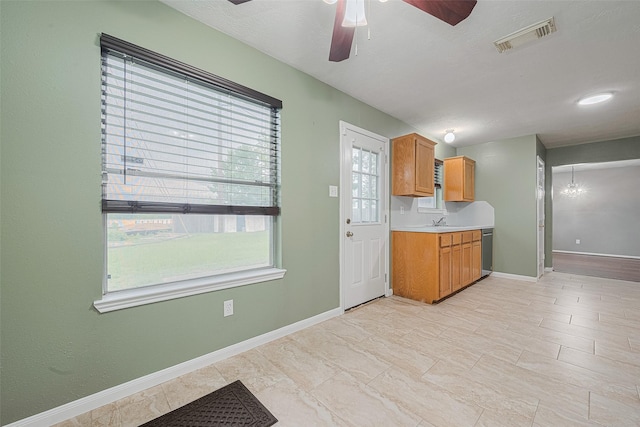 10834 Glenora Dr, Houston, TX 77065 - kitchen featuring dishwasher, a ceiling fan, light countertops, brown cabinetry, and a chandelier
