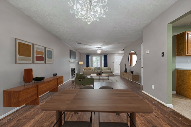 10834 Glenora Dr, Houston, TX 77065 - dining area featuring a textured ceiling, wood finished floors, a fireplace, a ceiling fan, and a chandelier