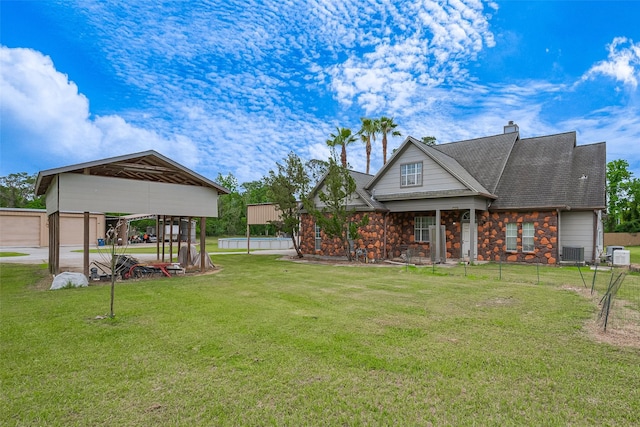 view of front of home with a front yard, fence, a pool, a shingled roof, and stone siding