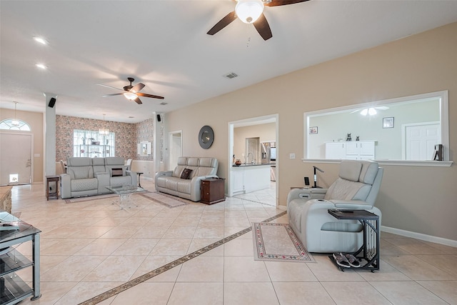 living area featuring baseboards, a ceiling fan, light tile patterned flooring, and visible vents