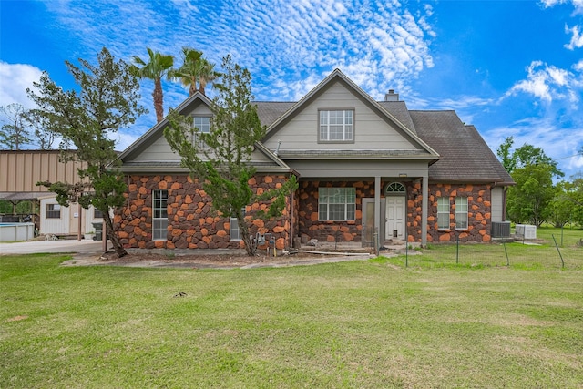 craftsman inspired home with covered porch, a front yard, central AC unit, and stone siding