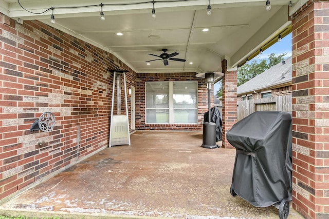 view of patio with fence, a ceiling fan, and a grill