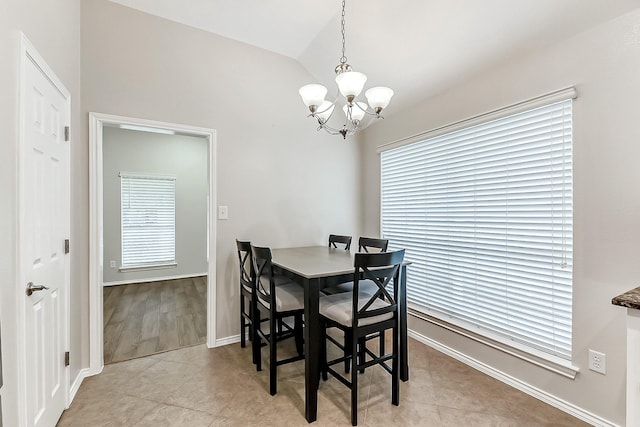 dining room with an inviting chandelier, baseboards, light tile patterned floors, and lofted ceiling