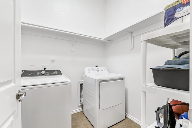 laundry area with washing machine and clothes dryer, light tile patterned flooring, laundry area, and baseboards