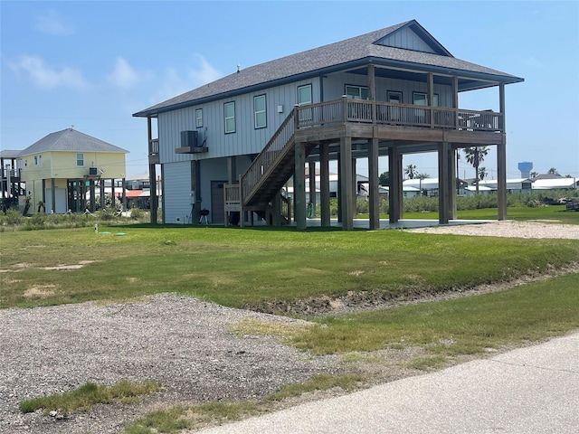 rear view of property featuring a lawn, board and batten siding, roof with shingles, and a carport