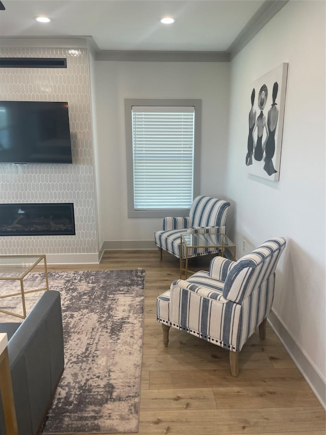 sitting room with crown molding, baseboards, recessed lighting, and wood finished floors