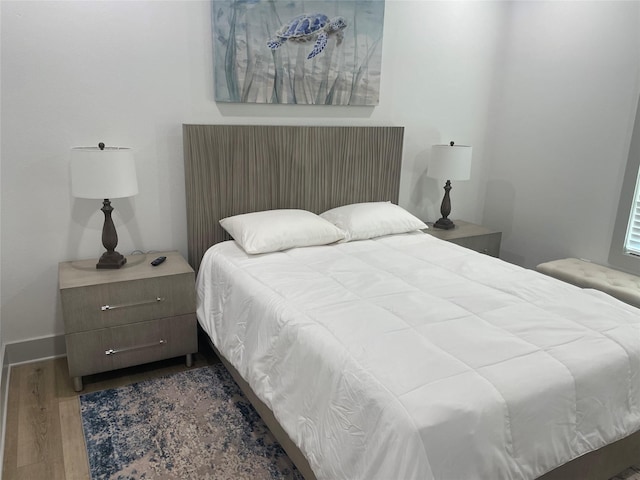 bedroom featuring baseboards and wood finished floors