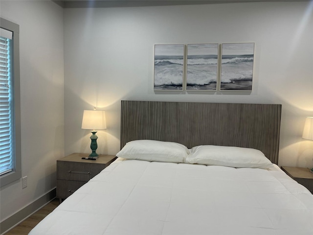 bedroom with baseboards and dark wood finished floors