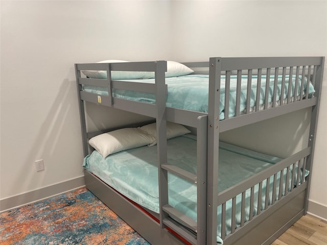 bedroom with baseboards and wood finished floors