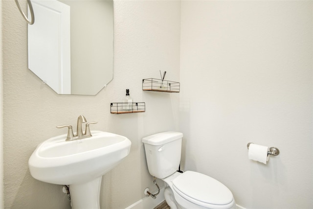7709 Rainbow Close Ln, Houston, TX 77055 - half bathroom with toilet, baseboards, and a sink