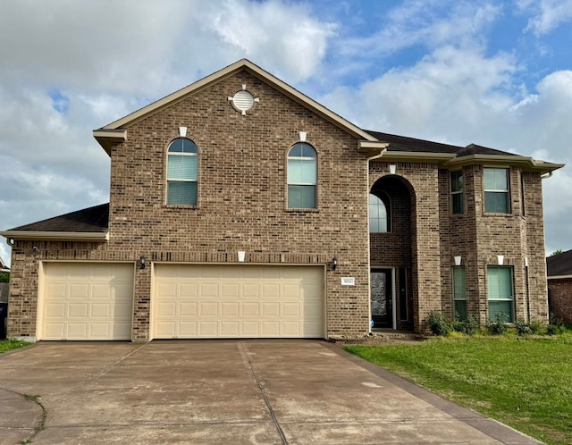 view of front of property with brick siding, a garage, a front lawn, and driveway