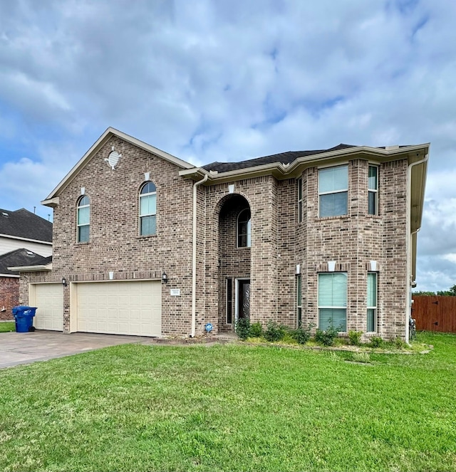 raised ranch with a front yard, brick siding, fence, concrete driveway, and an attached garage