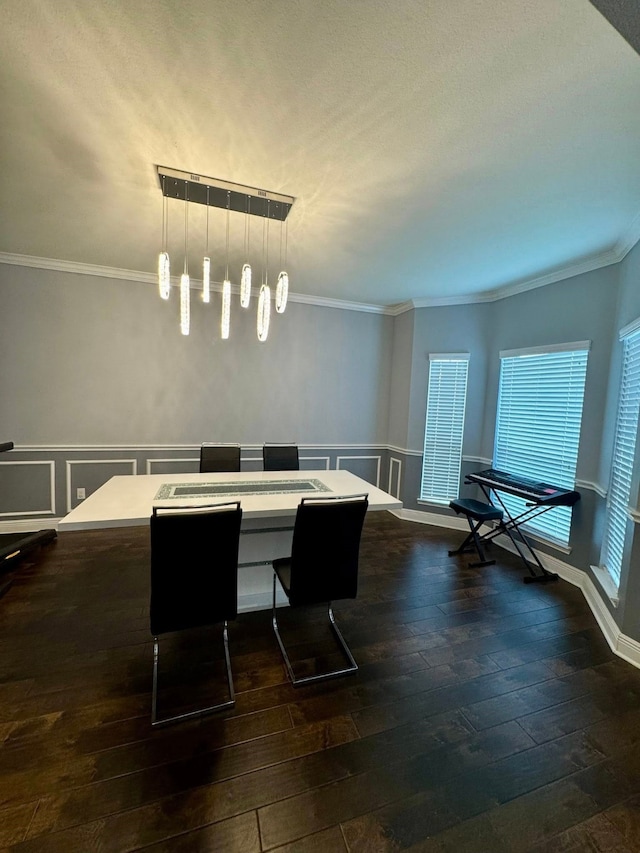 dining room featuring crown molding, dark wood-style flooring, and wainscoting