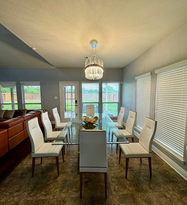 interior space with baseboards, a notable chandelier, and lofted ceiling
