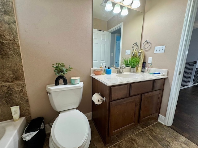 bathroom featuring toilet, baseboards, a bathtub, and vanity
