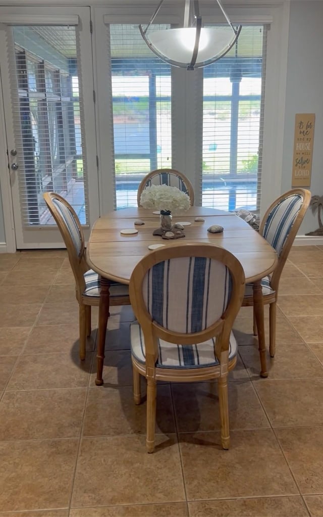 dining space featuring baseboards and light tile patterned flooring