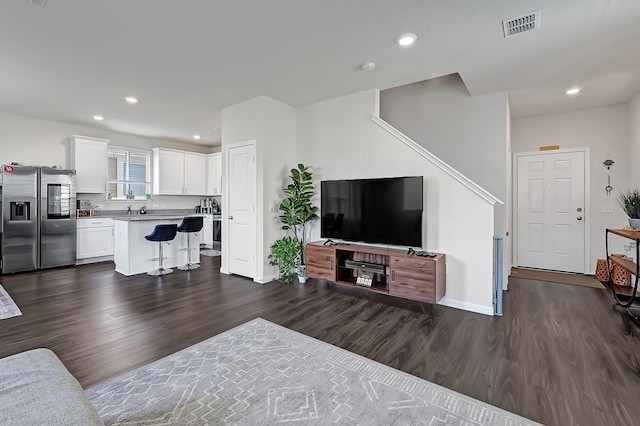 living room with recessed lighting, baseboards, dark wood finished floors, and visible vents