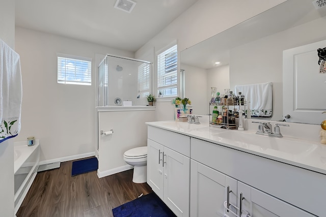 full bath with a sink, a shower stall, toilet, and visible vents