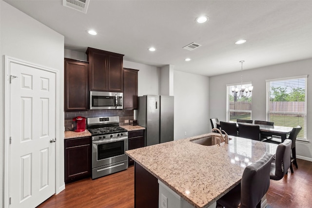 kitchen with visible vents, a sink, appliances with stainless steel finishes, and a chandelier