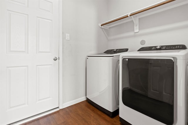 washroom with baseboards, laundry area, dark wood-type flooring, and washer and clothes dryer