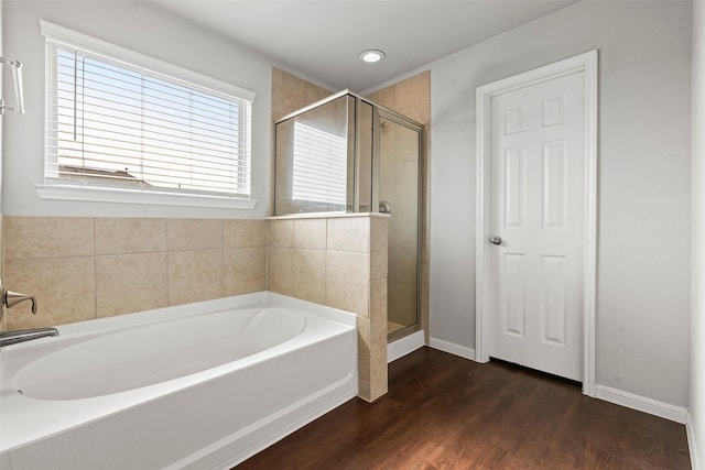 bathroom featuring recessed lighting, baseboards, a shower stall, wood finished floors, and a garden tub