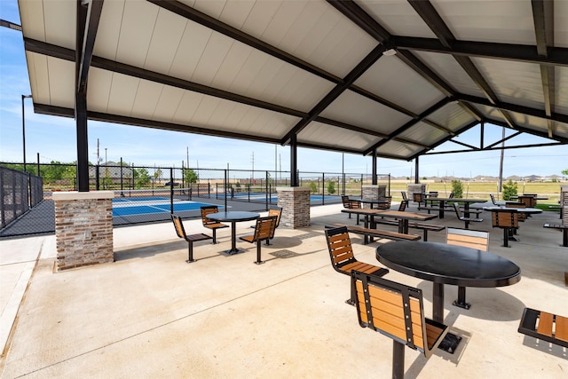 surrounding community with fence and a tennis court