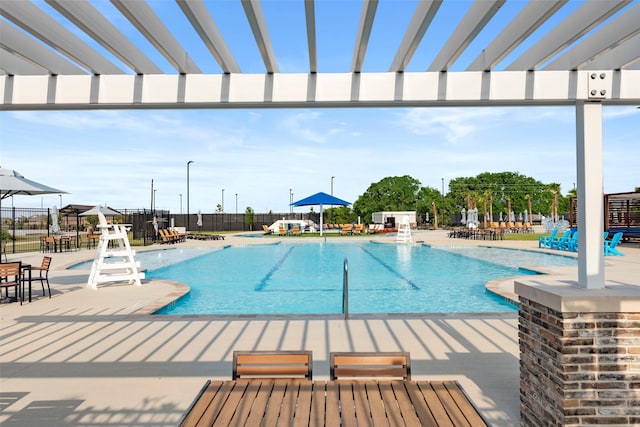 pool with a patio area and fence