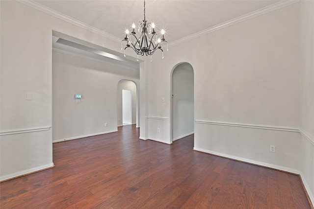 spare room featuring dark wood-style flooring, an inviting chandelier, arched walkways, baseboards, and ornamental molding