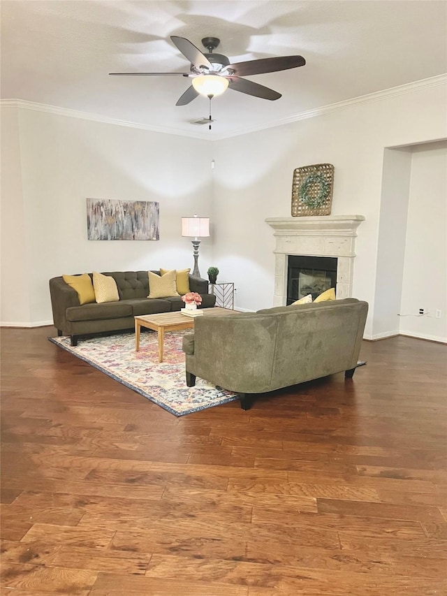 living area featuring a glass covered fireplace, ornamental molding, ceiling fan, and wood finished floors