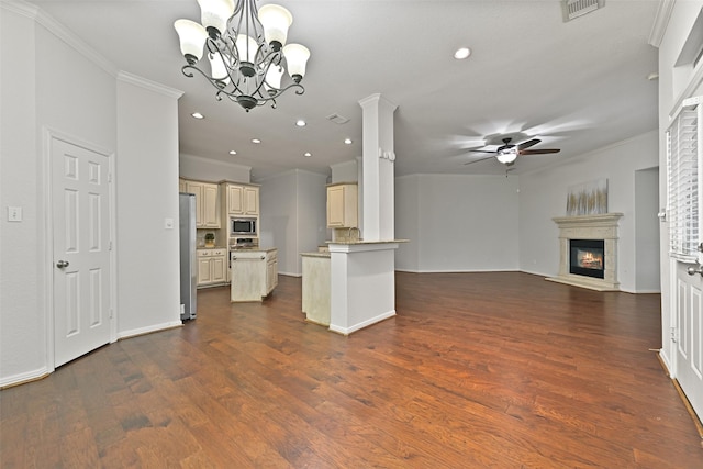 kitchen with crown molding, ceiling fan with notable chandelier, open floor plan, cream cabinetry, and appliances with stainless steel finishes