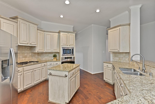 kitchen featuring a sink, appliances with stainless steel finishes, cream cabinets, and dark wood-style floors