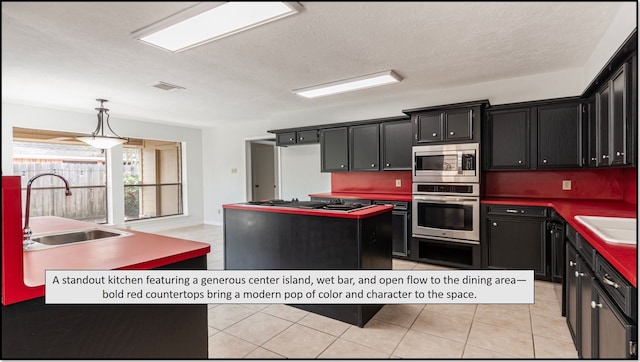 6627 Gleneagles Dr, Pasadena, TX 77505 - kitchen with dark cabinets, a sink, appliances with stainless steel finishes, and a kitchen island