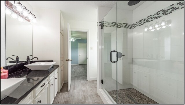 6627 Gleneagles Dr, Pasadena, TX 77505 - full bathroom with a ceiling fan, a shower stall, a sink, and wood finished floors
