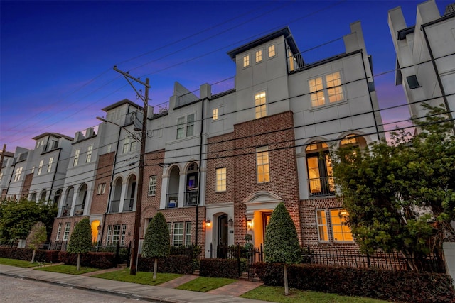 multi unit property with brick siding and a residential view