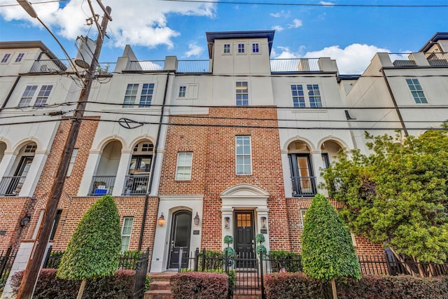 townhome / multi-family property featuring stucco siding and brick siding
