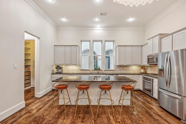 kitchen featuring crown molding, a breakfast bar, and stainless steel appliances