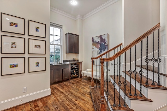 foyer entrance with crown molding, baseboards, dark wood-style floors, and stairs