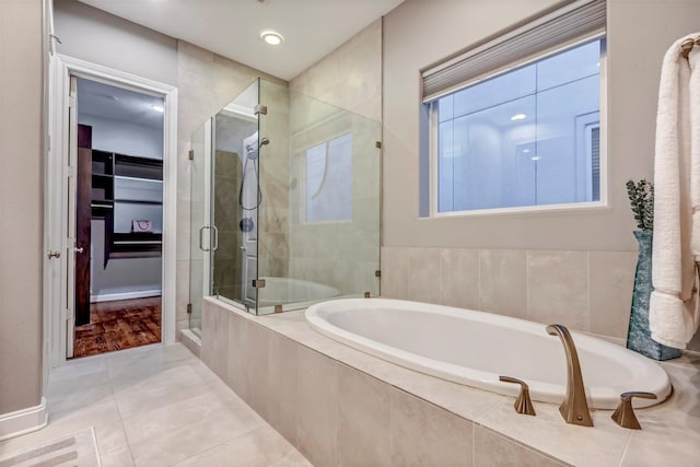 full bath featuring a garden tub, baseboards, recessed lighting, tile patterned floors, and a shower stall