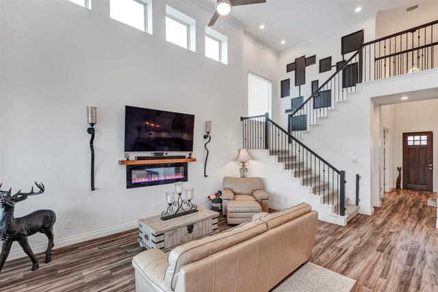 6006 Henry Hamlet Dr, Conroe, TX 77304 - living room with a high ceiling, ceiling fan, wood finished floors, crown molding, and baseboards