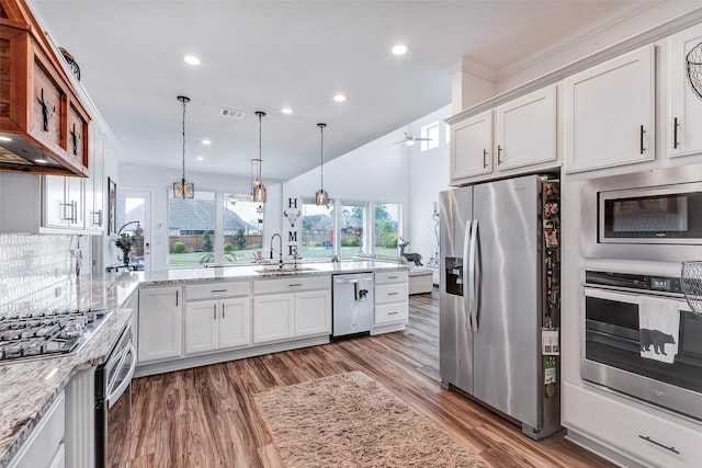 6006 Henry Hamlet Dr, Conroe, TX 77304 - kitchen featuring appliances with stainless steel finishes, a sink, white cabinetry, light stone counters, and recessed lighting