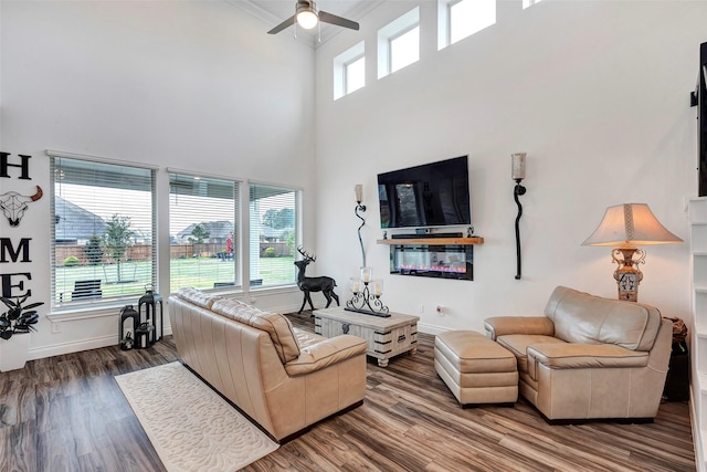 6006 Henry Hamlet Dr, Conroe, TX 77304 - living room featuring ceiling fan, wood finished floors, a high ceiling, baseboards, and crown molding