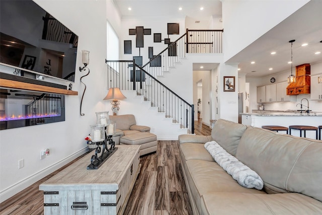 6006 Henry Hamlet Dr, Conroe, TX 77304 - living room with dark wood finished floors, stairs, baseboards, a towering ceiling, and recessed lighting