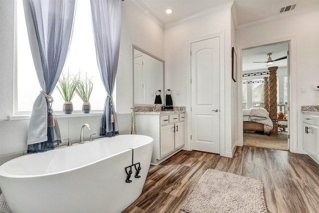 6006 Henry Hamlet Dr, Conroe, TX 77304 - ensuite bathroom featuring vanity, wood finished floors, crown molding, and a freestanding tub