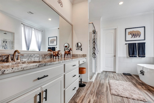 6006 Henry Hamlet Dr, Conroe, TX 77304 - bathroom featuring crown molding, vanity, a shower stall, a soaking tub, and wood finished floors