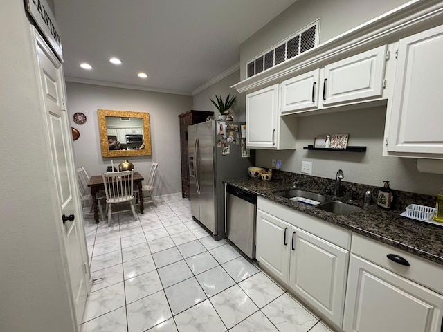 kitchen with visible vents, a sink, white cabinets, ornamental molding, and stainless steel appliances