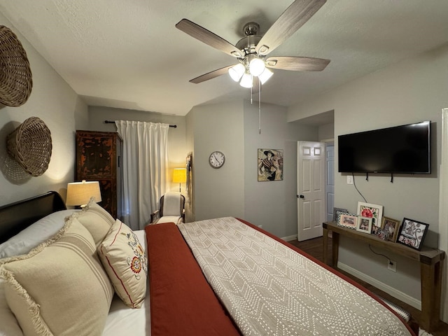bedroom featuring baseboards, ceiling fan, and wood finished floors