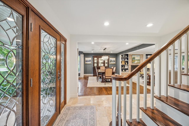 foyer entrance featuring stairway, baseboards, recessed lighting, and stone finish flooring